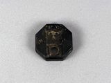 gros plan d'un petit objet métallique sur une surface blanche