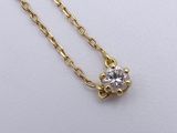 a gold necklace with a single diamond on a chain