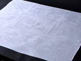 une serviette blanche ornée d'un monogramme, posée sur une table
