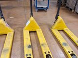 deux chariots élévateurs jaunes posés sur un plancher en bois dans un entrepôt