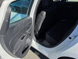 a small white car with its door open in the parking lot