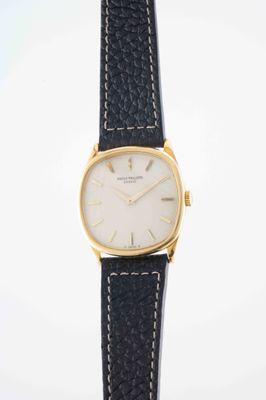 a close up of a watch on a white surface with a black strap