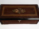 an old wooden box with a floral design on it