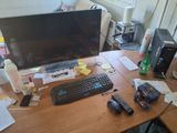 a desk with a computer, keyboard, mouse, and other items on it