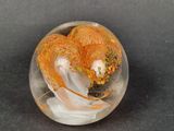 a glass ball with a yellow and white swirl inside of it