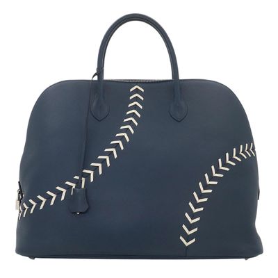 a blue leather bag with white stitching on the side