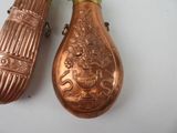 two copper vases sitting next to each other on a table
