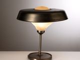 un gros plan d'une lampe posée sur une table, sur fond gris