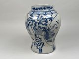 a blue and white vase sitting on a white surface