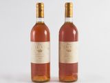 two bottles of wine sitting next to each other on a white surface