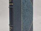 un livre bleu orné de lettres dorées, posé sur une surface blanche