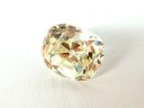 gros plan d'un diamant jaune sur une surface blanche