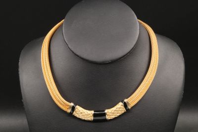 a gold and black necklace on a mannequin neck