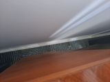 a cat that is hiding under a bed