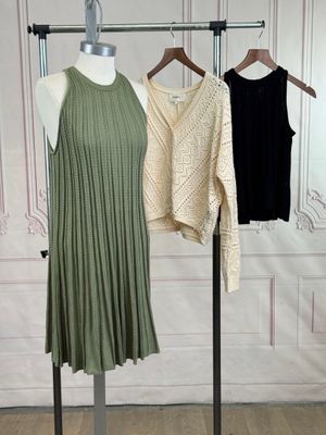 two women ' s dresses hanging on a rack in front of a wall