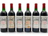 six bouteilles de vin sont alignées sur une surface blanche