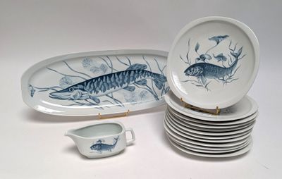 many plates and bowls that have fish on them
