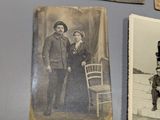 an old photo of a man and a woman standing next to a chair