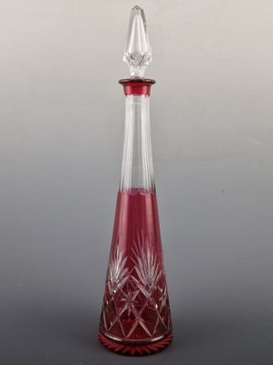 une carafe en verre rouge sur fond gris