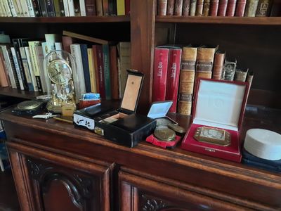 de nombreux livres sur une étagère, avec une horloge et d'autres objets