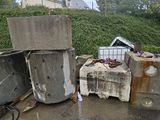 a pile of trash sitting on the side of the road