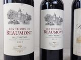 three bottles of red wine are lined up on a table