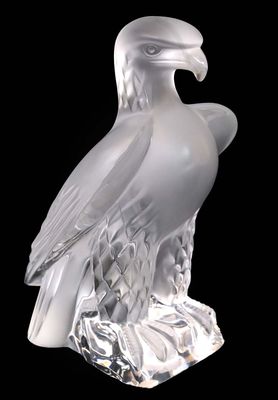 a glass sculpture of an eagle on a black background