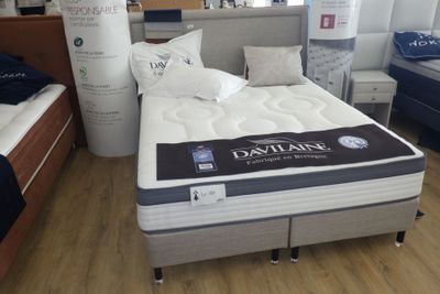 un lit sur lequel est posé un matelas dans une pièce