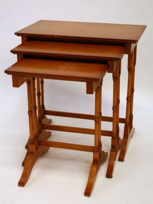 three wooden nesting tables sitting on top of each other on a white surface