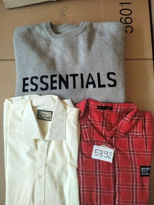 trois chemises pour homme posées sur une boîte en carton