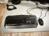 a computer keyboard and mouse on a desk next to a monitor