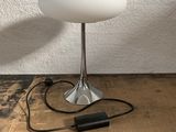an image of a table lamp on a wooden table with a charger