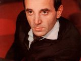 a man in a suit and tie sitting on a red couch