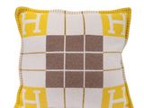 un oreiller jaune et blanc orné d'un motif à carreaux