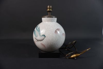 un vase blanc orné d'un oiseau, à côté d'une paire de ciseaux