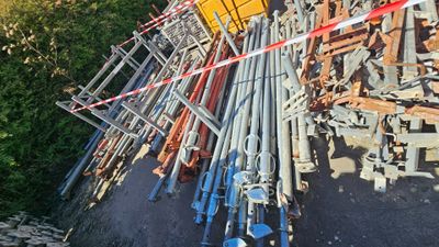 un gros tas de tuyaux métalliques posé sur le bord de la route