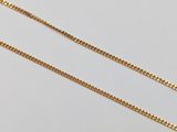 a gold chain with a single gold bead on a white background