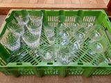 many empty wine glasses sitting in a green crate