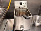 une friteuse dans une cuisine professionnelle, équipée d'un tuyau