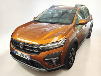 un gros plan d'une voiture orange garée dans une pièce blanche