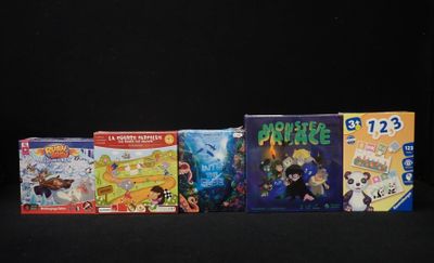 Plusieurs jeux de société pour enfants sont alignés sur une surface noire