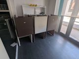 a kitchen with a table, chairs, and a refrigerator in it