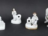 six porcelain figurines of dogs and people on a black background