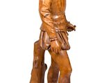 wooden statue of a man with a dog on a wooden base