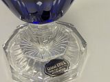 a blue glass vase sitting on a white table