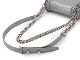 silver purse with chain strap on white background on white surface