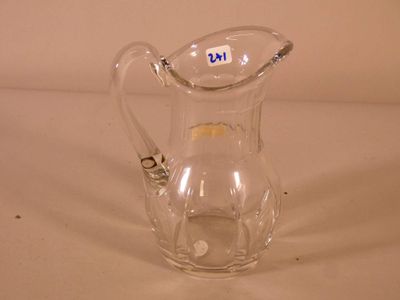 a clear glass pitcher with a handle on a table