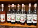 many bottles and glasses on a shelf in a bar
