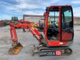a red excavator that is parked in a parking lot