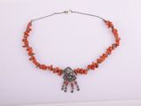 un collier composé de perles de corail et d'argent sur fond blanc
